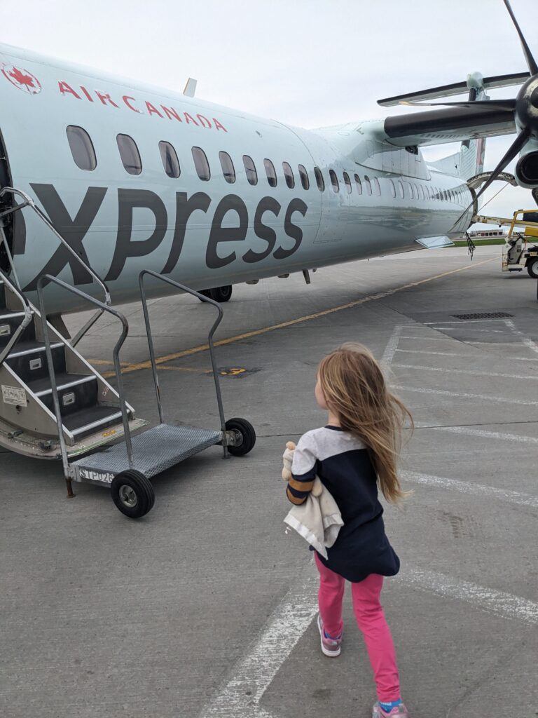 Little blond haired girl boarding an Air Canada plane.