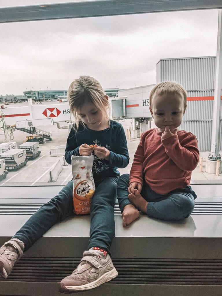 Des enfants mangent une collation pendant une escale - conseils pour voyager en avion avec des enfants et survivre à des escales avec des enfants