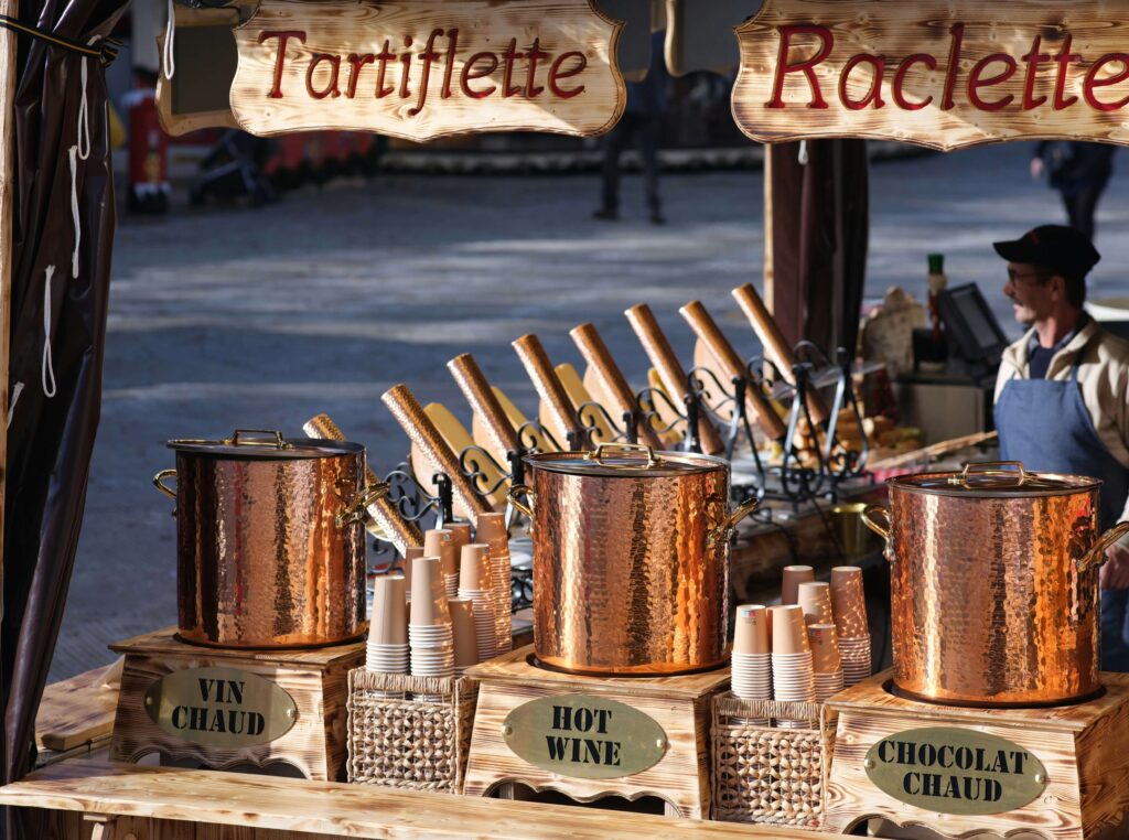 Hot wine and hot chocolate buckets at a wooden stand of a Christmas market.