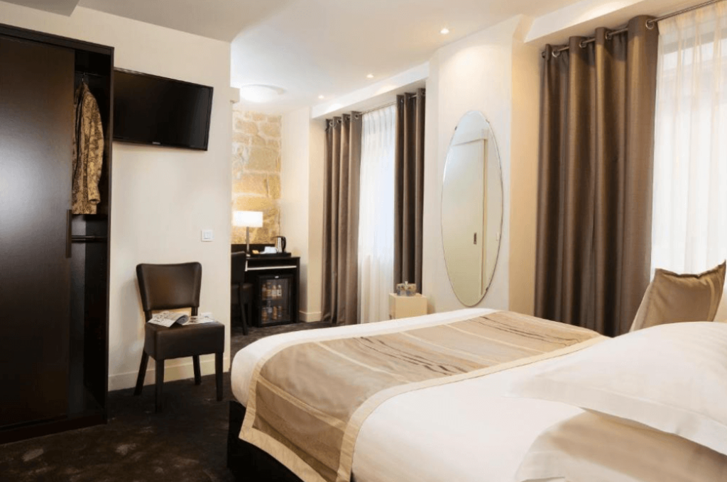 A hotel room with a double bed at the Hotel Lion d'Or Louvre Paris.