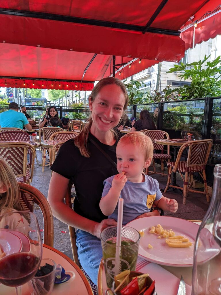 A mother and her toddler son sitting on a terrace in Paris in France. There are so many family-friendly restaurants and cafes in the center of Paris. 