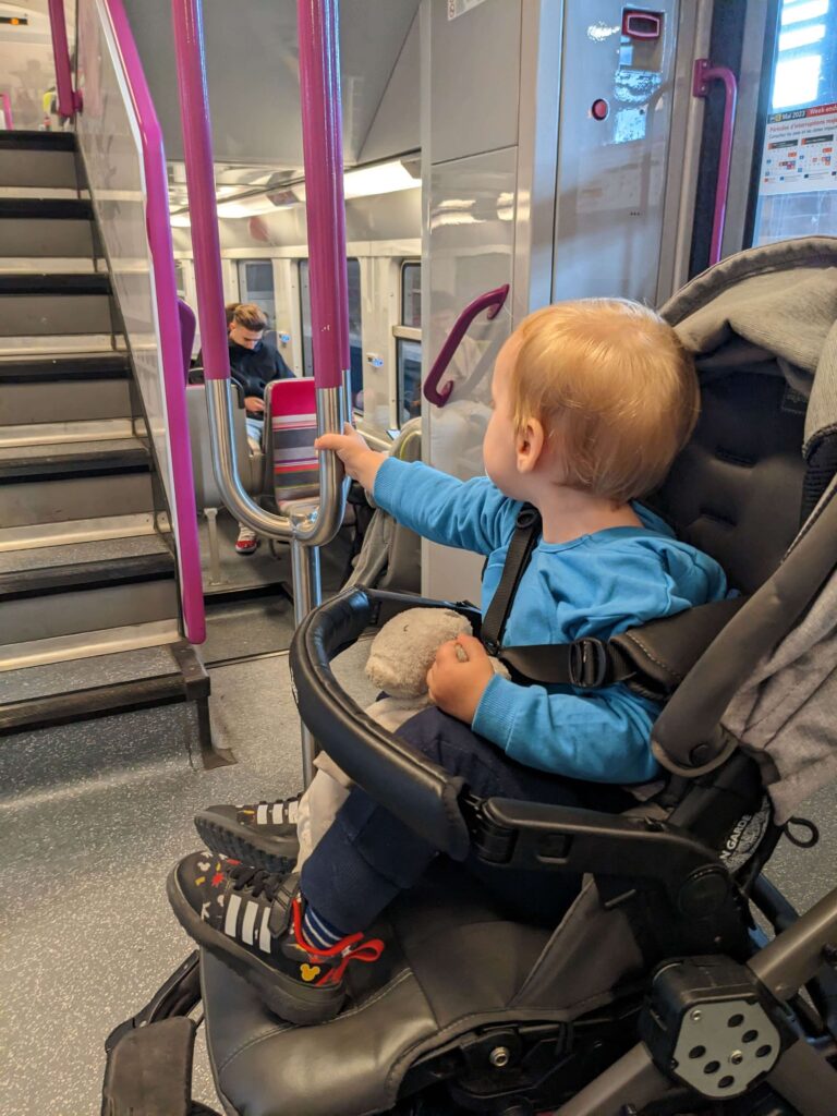 A toddler sitting in his stroller in a RER car in Paris. Public transports is a good way to get around the city if you're in Paris for one day only.