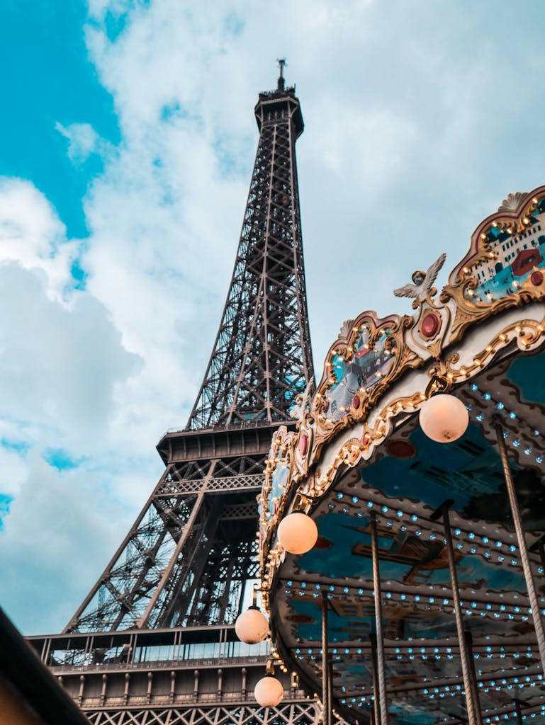 Eiffel Tower and vintage carousel in Paris, captured in a nostalgic low-angle shot.