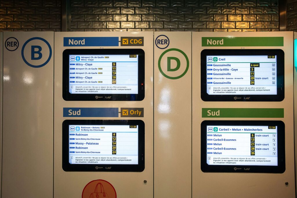 Screens on the wall of a RER train station in Paris. The RER is a budget-friendly way to get from Charles de Gaulle to Paris with kids.