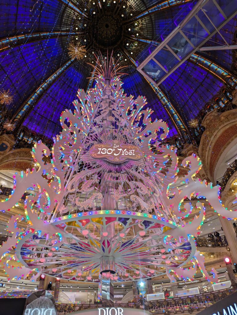 The Christmas tree at Galeries Lafayette lit up at night. It's one of the most famous activities in Paris at Christmas for families.