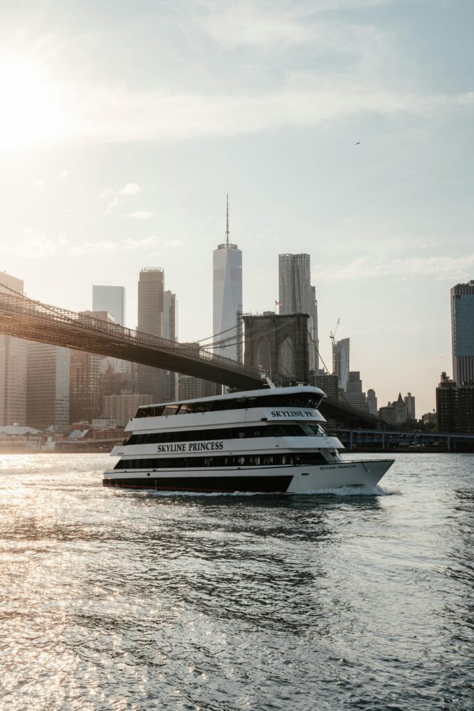 Skyline Princess Ferry in New York City under one of the famous bridges. The ferry is one of the coolest ways of getting around NYC with kids on a family trip.