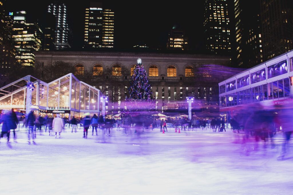 Skating rink with purple lights for the holiday season at Bryant Park in New York City. It's one of the spots where families can see Santa in NYC before Christmas.