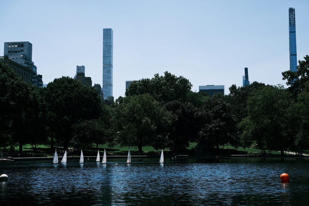 Model boats floating on the the pond of the Conservatory Water in Central Park in New York City, This is one of the best hidden gems in New York for families lookies for a quiet spot to have fun.