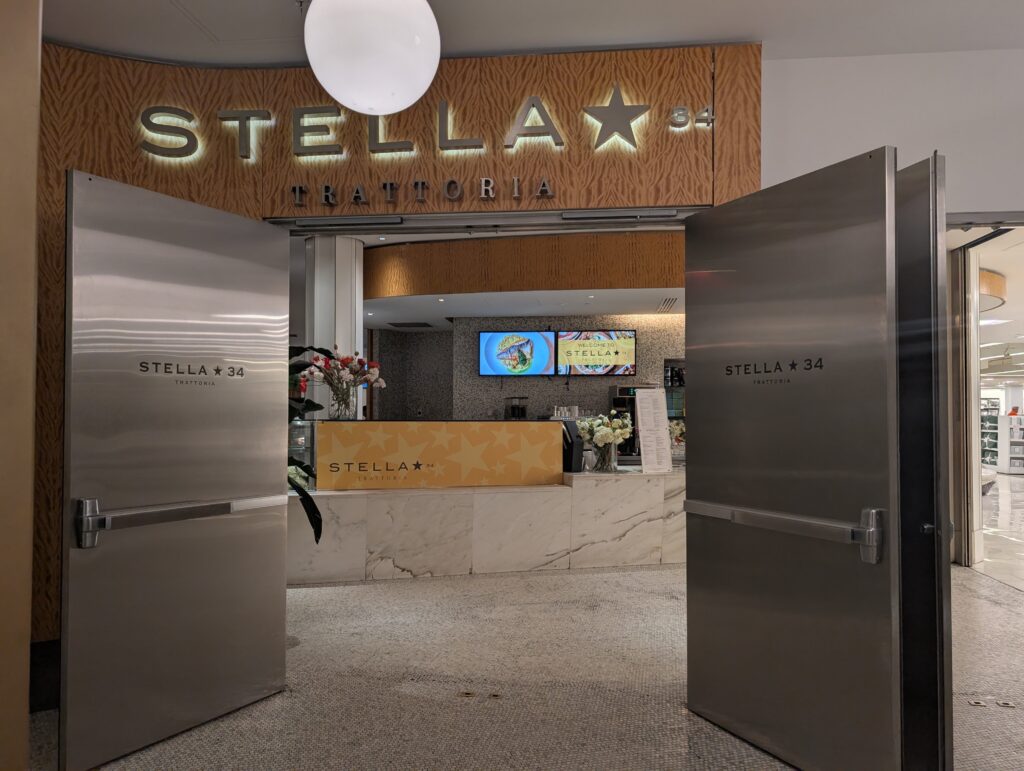 Entrance to Stella 24 Trattoria, a family-friendly NYC restaurant above Macy's mall. 