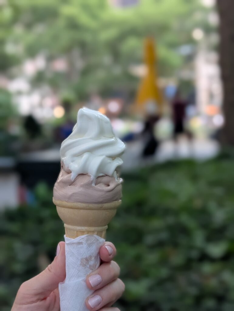 Twist ice cream cone in a woman's hand in Bryant Park, NYC.