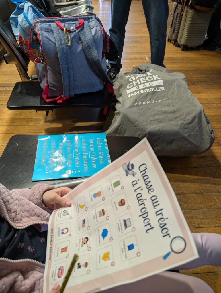 A girl staying entertained at the airport by completing the Family Aboard's Airport Scavenger Hunt while waiting to board a plane.