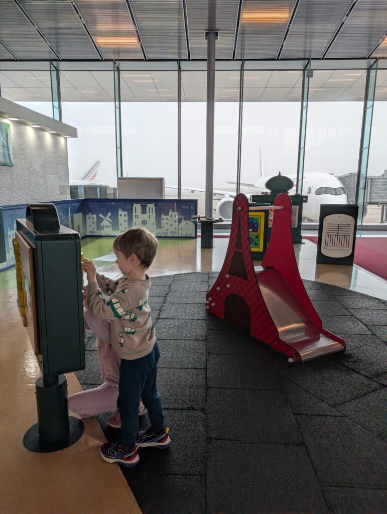 A pre-schooler boy playing on a board in a kids' play area at Charles de Gaulles airport in Paris.
