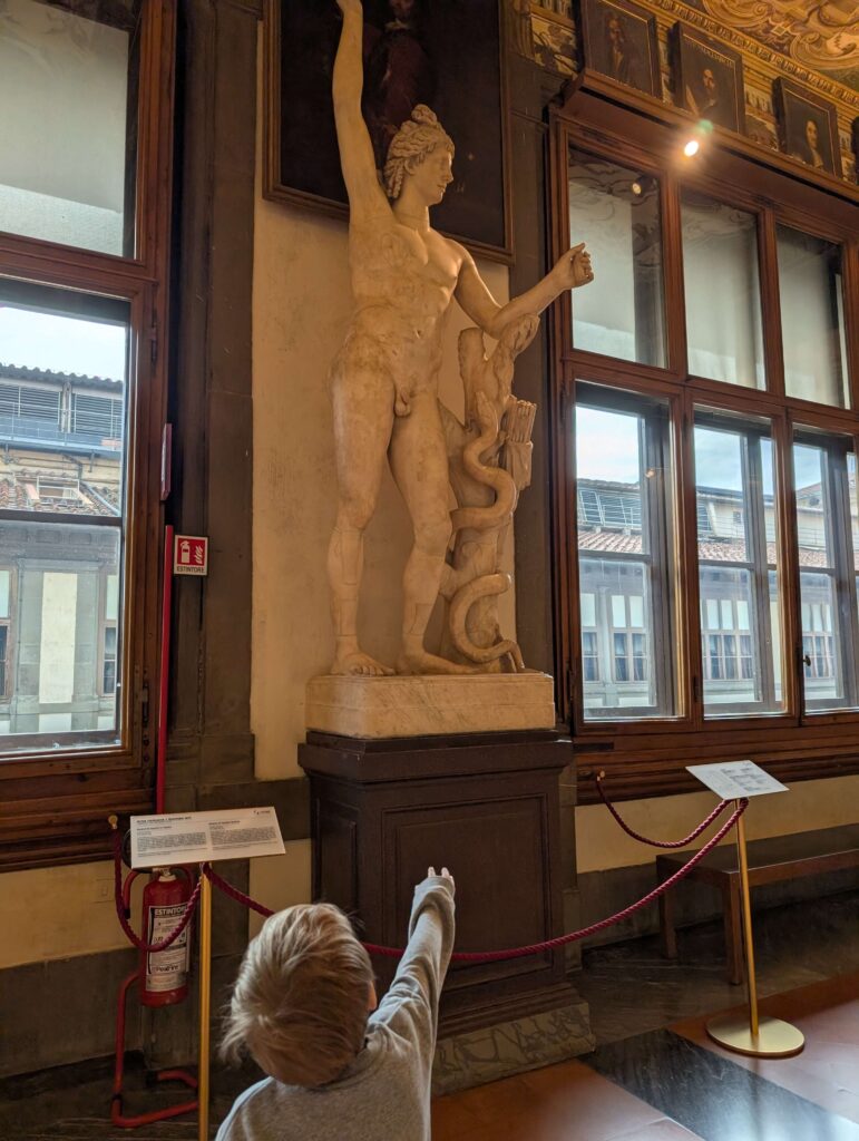 A little boy pointing a statute in the Uffizi Gallery in Florence, Italy. The musuem is worth visiting, even with kids.