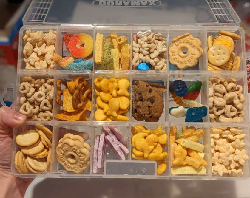 Boîte de collations surprises pour les enfants et les touts-petits en avions. Les collations sur l'image inclus des biscuits, bonbons et craquelins. Cette boîte de collation devrait toujours se retrouver dans le carry-on de votre enfant!